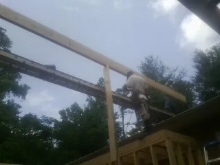 Carpenter setting a ridge beam over a new addition frame — Ice Dam Removal by Roofing Brothers in Shavertown