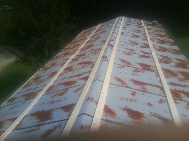 Rusted metal roof panels with new wood purlins before replacement — Storm Damage Roof Repair in Shavertown by Roofing Brothers