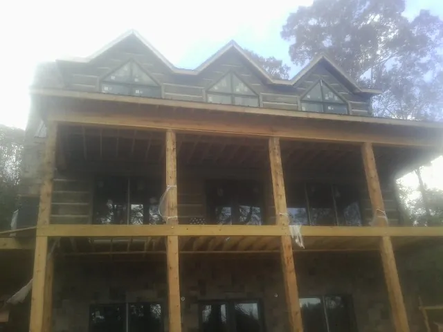 Dormers and porch framing on a large log home under construction — Roof Coating work by our crew in Shavertown